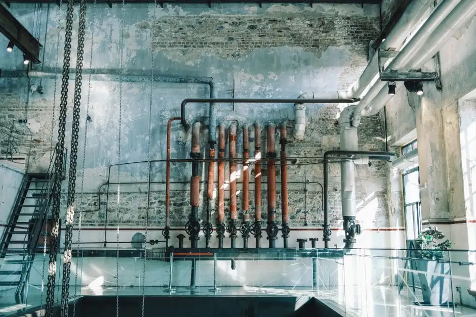 Rustic industrial scene featuring vintage pipes and brick walls in an old warehouse setting.